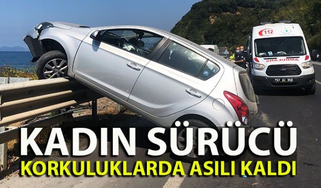 Kadın sürücünün hakimiyetini kaybettiği otomobil, park halinde duran otomobile çarptıktan sonra refüj üzerinde bulunan demir bariyer üzerine çıkarak asılı kaldı